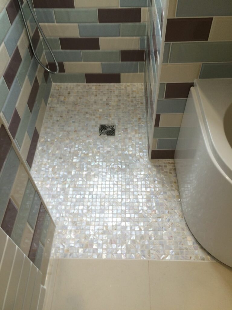 Mother of pearl mosaic tiling in walk-in shower.